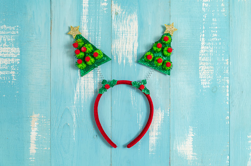 Christmas tree headband for kids on blue wooden background