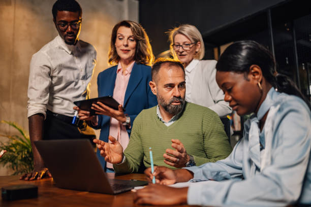 istock Interracial team with laptop at corporate office discussing strategy. 2149186154