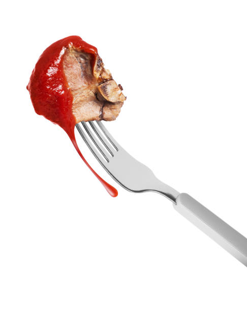istock Fried beef steak poured with tomato ketchup on a fork close up on a white background 2149186816