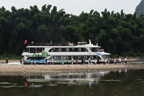 Yangshuo County, Guilin, Guangxi, China - July 29, 2023: A cruise ship carries tourists on the Li River