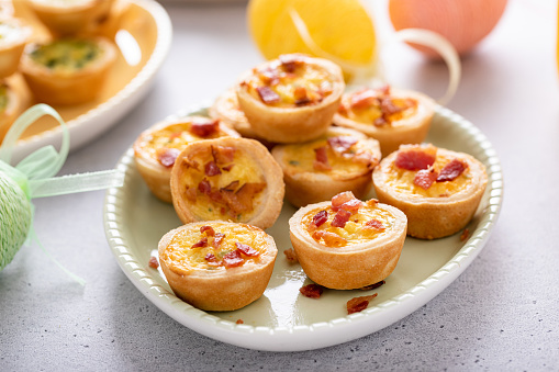 Mini quiches with ham and cheese topped with crispy bacon, ideas for Easter brunch or breakfast