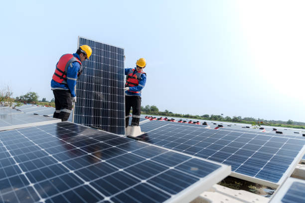 istock Male workers repair Floating solar panels on water lake. Engineers construct on site Floating solar panels at sun light. clean energy for future living. Industrial Renewable energy of green power. 2149188094
