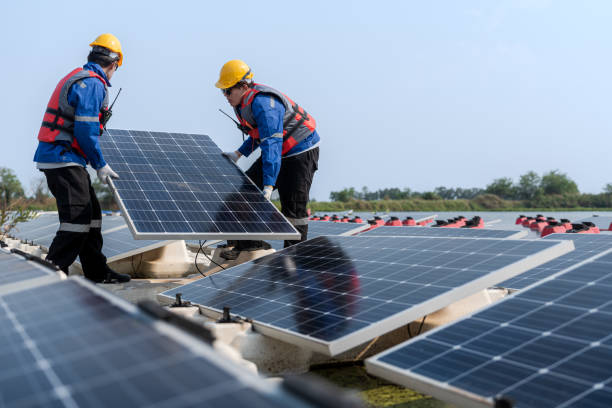 istock Male workers repair Floating solar panels on water lake. Engineers construct on site Floating solar panels at sun light. clean energy for future living. Industrial Renewable energy of green power. 2149188620