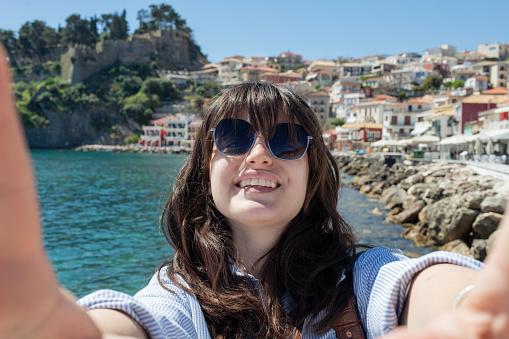 Female tourist taking selfie on summer vacation by the seaside.