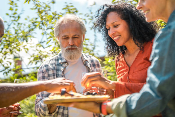 istock Smiling Senior Friends Enjoying Backyard Picnic 2149189265