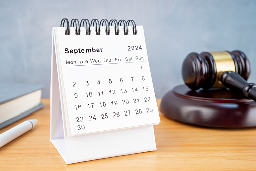 Desk calendar for September 2024 and judge's gavel on the worktable.