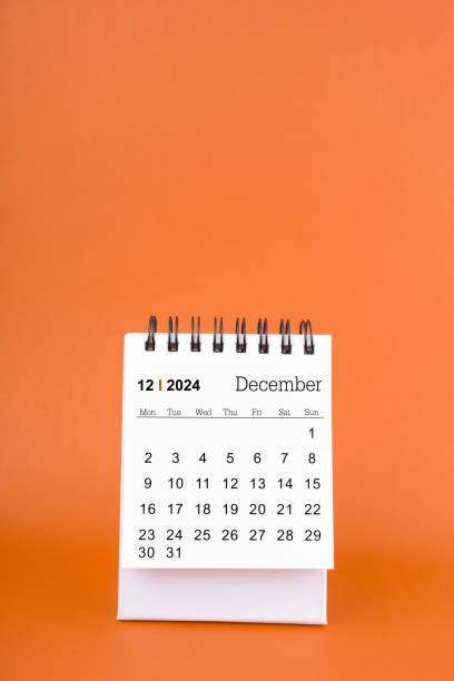 istock Vertical of December 2024 table calendar on orange background. 2149193175