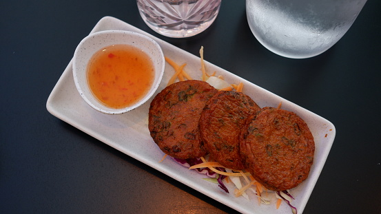 Thai fish patties or Tod Mun Pla is a Thai dishes made from ground fish mixed with Thai spices served with sweet and sour dipping sauce.