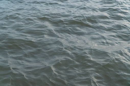 Abstract photo of water waves on the Tien River, a river carrying a lot of alluvium to build up the Mekong Delta
