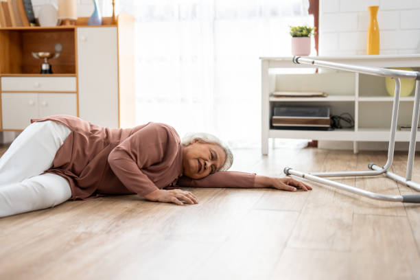 istock Asian senior elderly female fall on the ground while walk alone in house. Mature older grandmother having an accident and fainting while doing physical therapy after retirement in living room at home. 2149194155