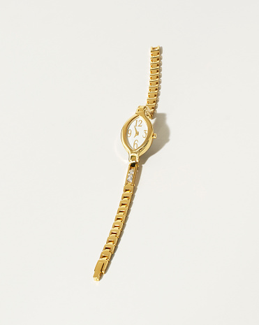 Still life shot of an expensive golden watch on white background