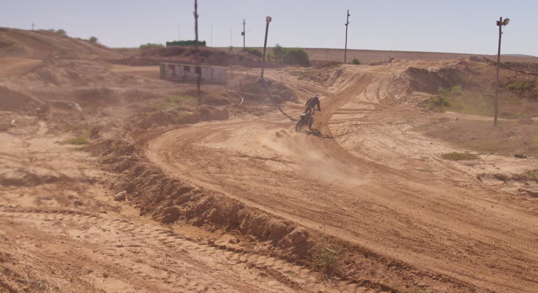 Motorcycle, speed and driver on sand trail with motorcross, power and rider outdoors. Man, motorbike and male person travel or riding on dirt track, performance and action or talent for freedom
