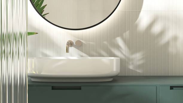 istock Modern white washbasin on dark green vanity counter countertop in sunlight on cream tile wall bathroom 2149195603