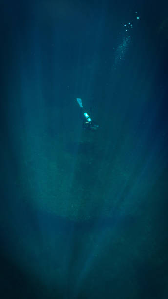 istock Scuba diver Descent into the deep blue in rays of light 2149195859