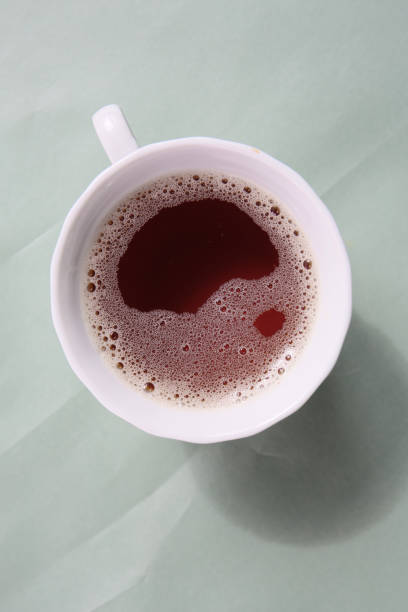 cup of hot black tea on a color background