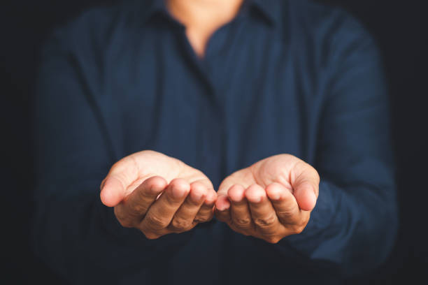 istock Man holding something in his hands on a dark background. 2149197333