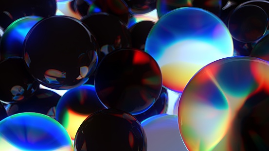 An array of dark spheres with a colorful glare..