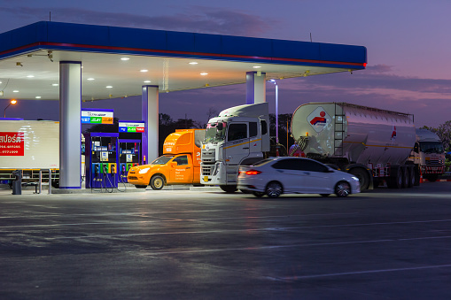 Mahasakham, Thailand - November 30,2021: PTT gasstation and cars being refueled during the time of sunset