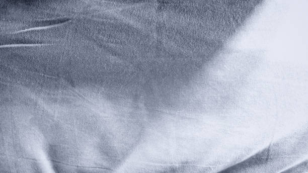 istock Background: wrinkled cloth texture mixed with small grains With gradient light in blue-gray tones. For backdrops, banners, frames, summer, graphics, motion, waves. 2149201199