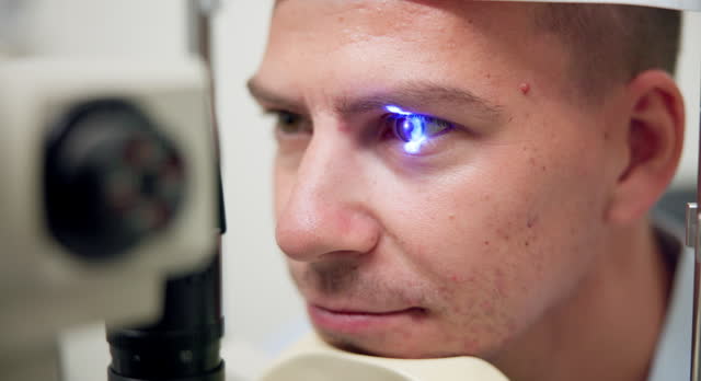 Closeup, slit lamp or optometry as eye, test or ophthalmology by visual, health or care in hospital. Lens, patient or led light as retina, glaucoma or assessment in consultation by optic expert