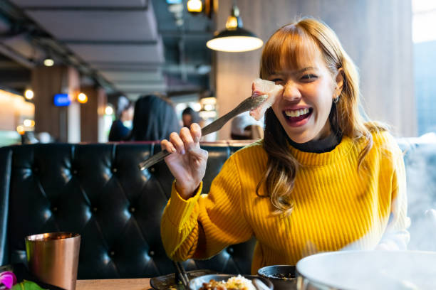 istock Asian woman having lunch eating hot pot at restaurant 2149202433