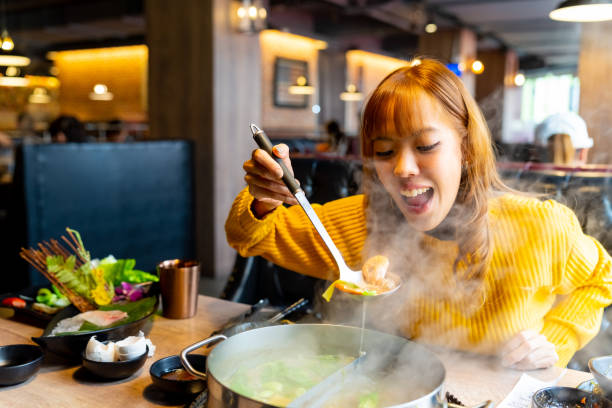 istock Asian woman having lunch eating hot pot at restaurant 2149202436