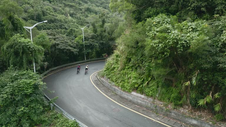 two young asian women cycling on rural road