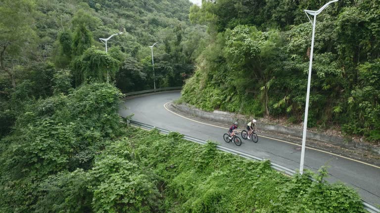 two young asian women cycling on rural road