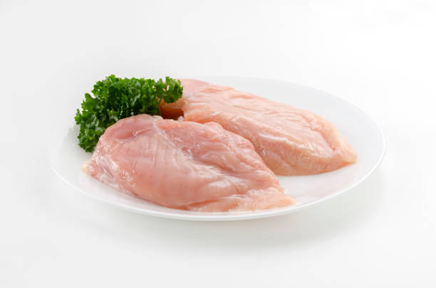 istock Raw Chicken breast with parsley on a  dish on white background 2149207599