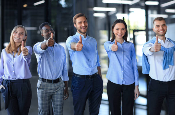 istock Happy businesspeople standing in office showing thumb up. 2149208846