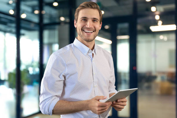 Handsome businessman using his tablet in the office.