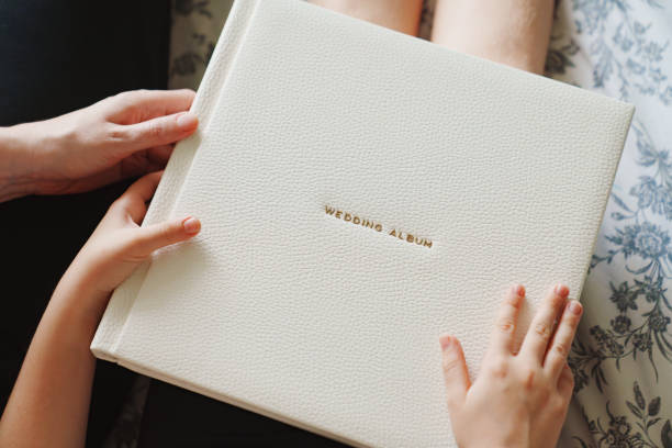 istock The hands are holding a wedding book in a white leather cover 2149210655