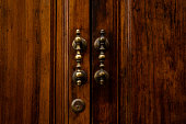 Old brown wooden door with antique handles, detail of a door. Metal knocker on a door