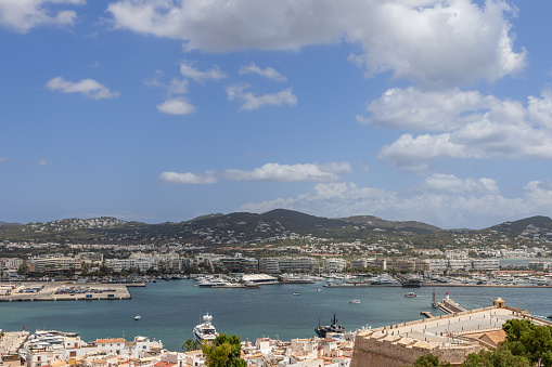 Ibiza - Spain. July 25, 2023: From a high vantage point, the marina of Eivissa in Ibiza unfolds with its serene blue waters and luxury yachts, framed by the quaint architecture of the town
