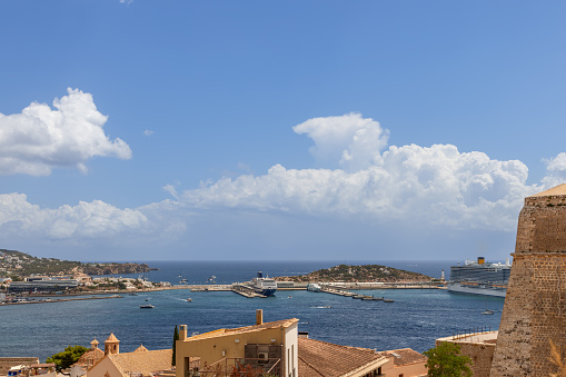 Ibiza - Spain. July 25, 2023: Captured from the historic Almudaina Castle walls in Ibiza old town, this view highlights the marina of Eivissa with moored cruise ships, set against the expansive Mediterranean Sea