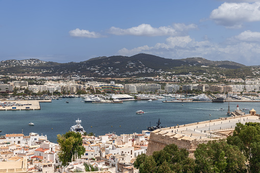 Ibiza - Spain. July 25, 2023: The Almudaina Castle walls offer a unique perspective over Eivissa port, blending the old town charm with the contemporary elegance of moored yachts and the natural beauty of Ibiza