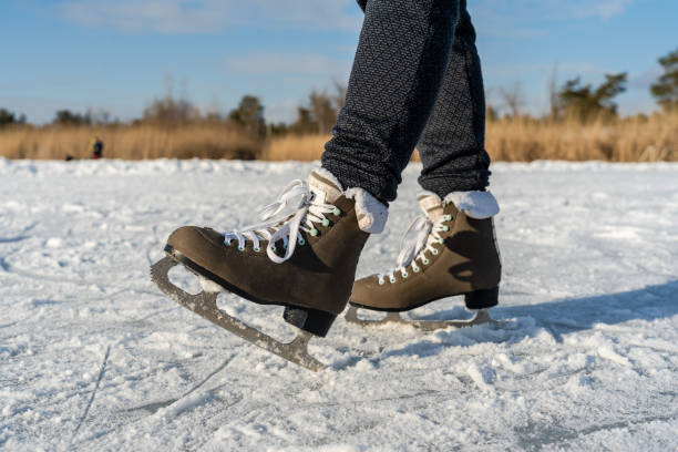 istock Women's figure skates on ice with a little bit snow 2149214243