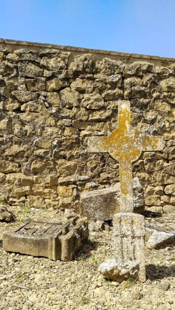 istock A stone wall with a cross in front of it 2149216140