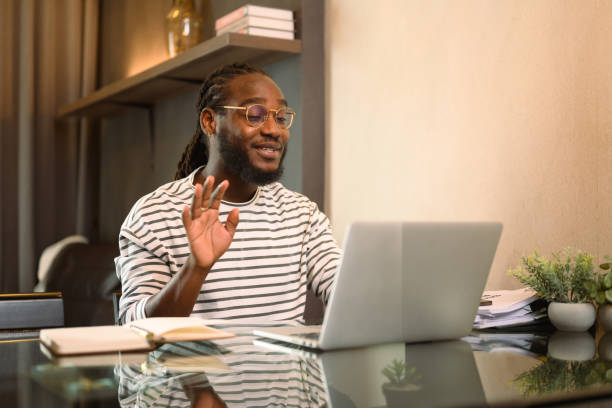 istock African American man working with laptop remotely while sitting at table in kitchen 2149216276