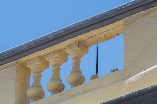 Restrictive concrete railing on the roof of the building with decorative balusters in antique style. Two of them were destroyed, missing and subject to restoration. Items of Historical Value.