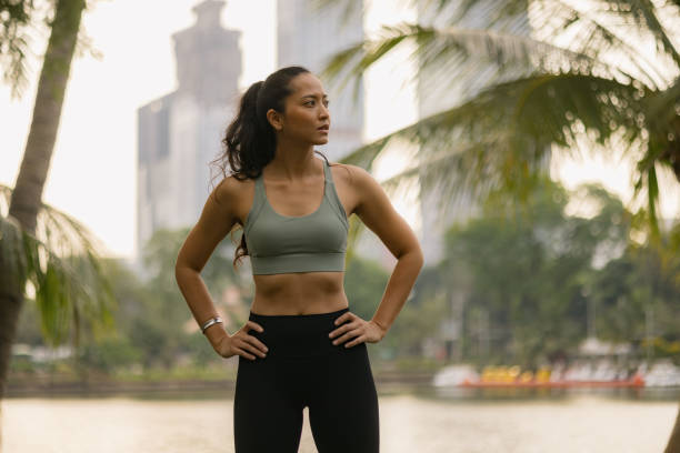istock Thoughtful Thai sportswoman on a break in the park. 2149220334