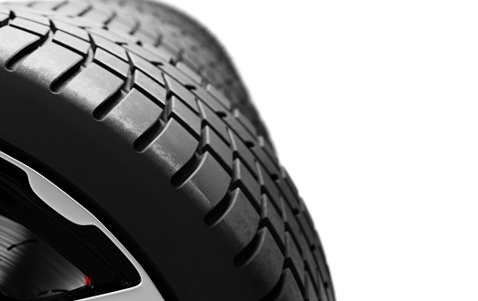 Close-up view of car tire tread on high-end wheel isolated.