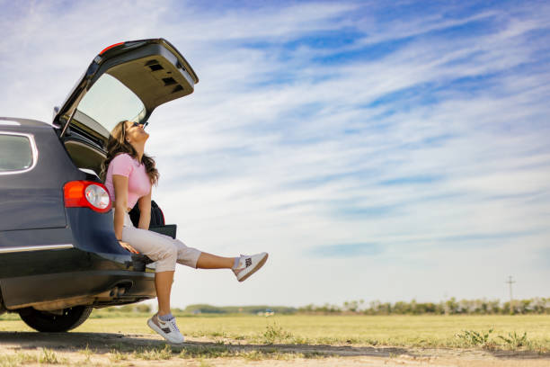 Young beautiful woman relaxing in the car trunk