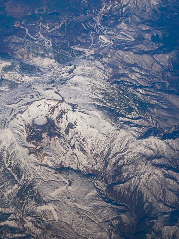 Aerial view of the snowy Zao Mountain Range from an airplane window over Zao Town, Yamagata Prefecture on a sunny day in April 2024
