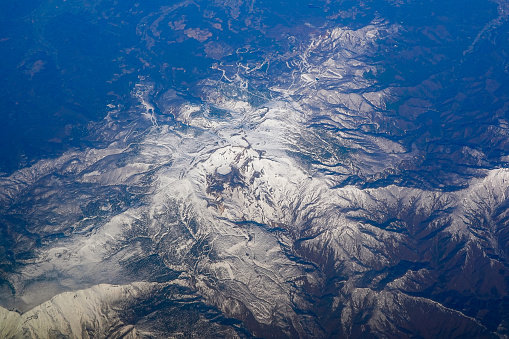 Aerial view of the snowy Zao Mountain Range from an airplane window over Zao Town, Yamagata Prefecture on a sunny day in April 2024