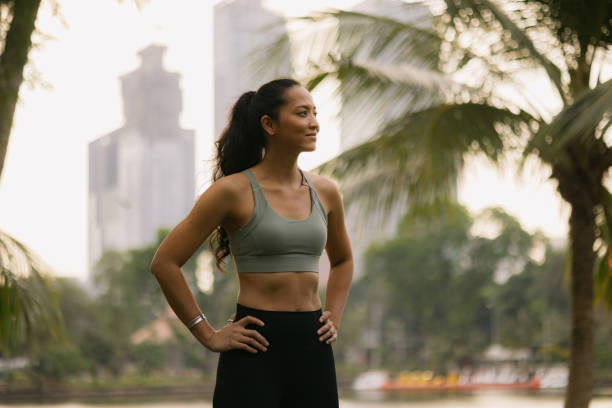istock Thoughtful Thai athletic woman on a break in the park. 2149223025