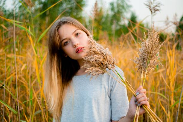 Young woman sitting on yellow grass