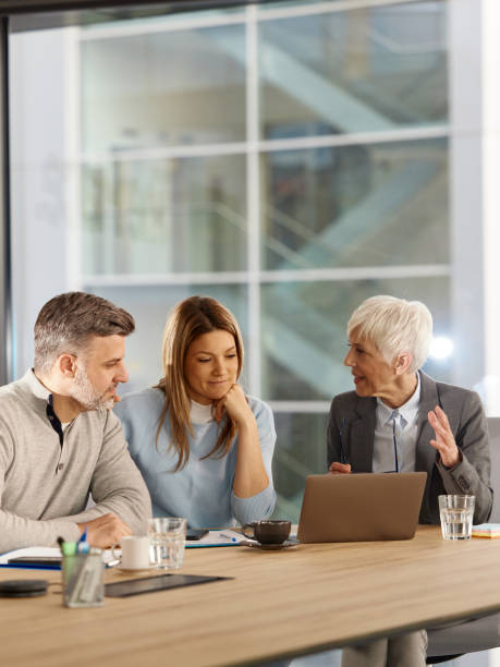 istock Senior advisor using laptop with her customers in the office. 2149223530