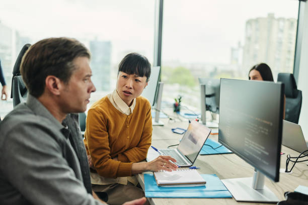 istock Business colleagues talking about codes on desktop PC in the office. 2149224389