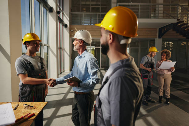 istock Happy project manager greeting a construction worker in the building. 2149225017